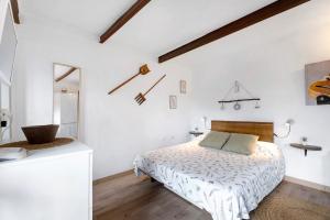a white bedroom with a bed and a mirror at Casa Tajaraste 1 in Hermigua