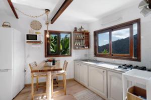 a kitchen with white cabinets and a table and a window at Casa Tajaraste 1 in Hermigua