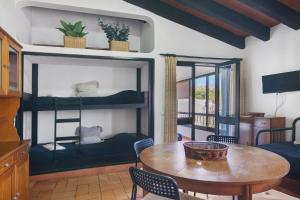 a living room with a table and chairs and a room with bunk beds at Pedras Del Rei 8 in São Pedro