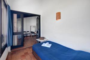 a bedroom with a blue bed and a balcony at Pedras Del Rei 8 in São Pedro