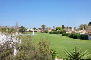 a large green yard with people sitting on the grass at Pedras Del Rei 8 in São Pedro