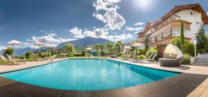 Ein Hotelpool mit Bergen im Hintergrund in der Unterkunft Passerblick in Dorf Tirol