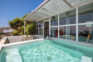 a swimming pool in front of a house at Loft Amanecer in Mácher