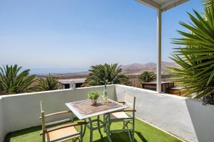 a table and chairs on the balcony of a house at Loft Amanecer in Mácher