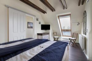 a bedroom with a large bed and a television at Ferienhaus Martje in Hennstedt