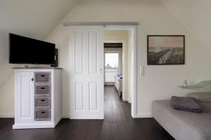 a living room with a flat screen tv on a wall at Ferienhaus Martje in Hennstedt