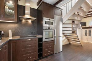 a kitchen with wooden cabinets and a spiral staircase at Ferienhaus Martje in Hennstedt