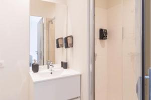 a white bathroom with a sink and a mirror at Merlot in Ruoms +17 photos