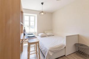 a small bedroom with a bed and a desk at Merlot in Ruoms