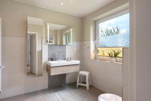 a bathroom with a sink and a mirror at Gästehaus Tadenswarf in Tadenswarf +46 photos