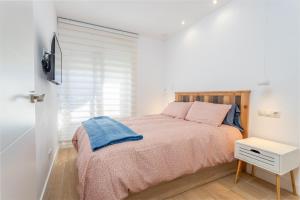 a bedroom with a bed and a tv on a wall at Apartamento Tamarindos 500 in L'Estartit +15 photos