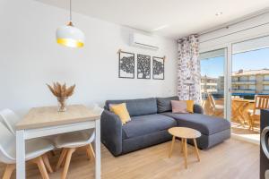 a living room with a blue couch and a table at Apartamento Tamarindos 500 in L'Estartit