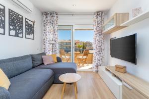 a living room with a blue couch and a flat screen tv at Apartamento Tamarindos 500 in L'Estartit