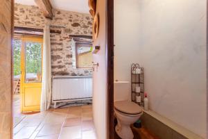 a bathroom with a toilet and a window at Mas Vizern avec bain nordique in Taillet +25 photos
