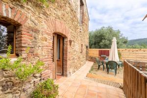 a patio with a table and a patio umbrella at Mas Vizern avec bain nordique in Taillet