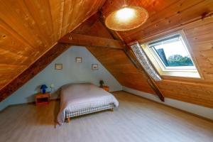 a attic bedroom with a bed and a window at Loft Atypique jacuzzi sauna in Cléguérec