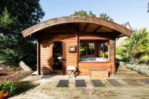 a small wooden cabin with a glass door at Loft Atypique jacuzzi sauna in Cléguérec