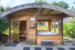 a wooden shed with a hot tub in it at Loft Atypique jacuzzi sauna in Cléguérec +29 photos