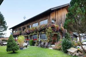 a building with a lot of flowers on it at Haus Vögel in Sibratsgfäll