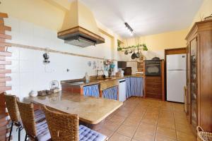 a kitchen with a table and a refrigerator at Casa Rústica in Silves