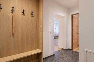 a hallway with white walls and wood paneling at Mountain Meadows Apt 4 in Valdaora