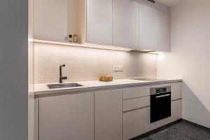 a kitchen with white cabinets and a sink at Mountain Meadows Apt 4 in Valdaora +15 photos