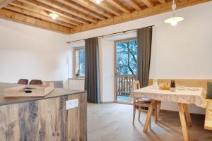 a kitchen and dining room with a table and a table and chairs at Alpin Chalet Samer Apt Bauernstube in Sarntal