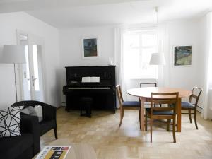 a living room with a table and a piano at Schlößleweg 2a in Bodman-Ludwigshafen