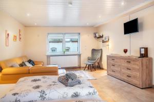 a living room with a bed and a couch and a television at Ferienwohnung Weingeist in Reil