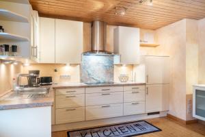 a kitchen with white cabinets and a sink at Ferienwohnung Weingeist in Reil