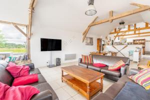 a living room with couches and a tv at Gîte Le Jardin d'Eden in Bovel +17 photos
