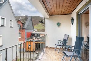 a balcony with chairs on a house at Ferienwohnung Weingeist in Reil