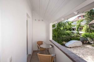 a balcony with a table and chairs and a window at Haus Behr am See in Radolfzell am Bodensee +12 photos