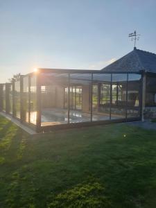a pavilion with the sun setting in a field at Gîte Le Jardin d'Eden in Bovel