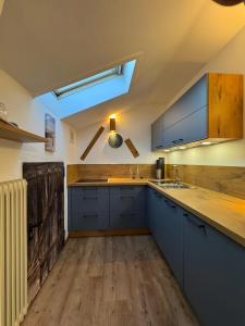 a kitchen with blue cabinets and a skylight at Aschaubichl - Wohnung Narzisse in Grainau
