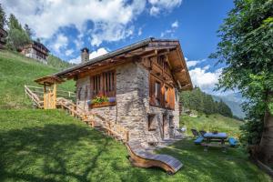 a small log cabin with a table and a bench at Baita Mas Sternai Nel Parco in Bagni di Rabbi