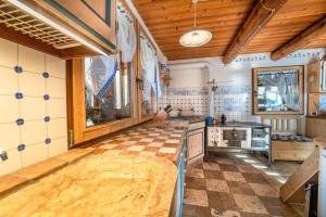 a kitchen with a checkered floor and wooden ceilings at Baita Mas Sternai Nel Parco in Bagni di Rabbi