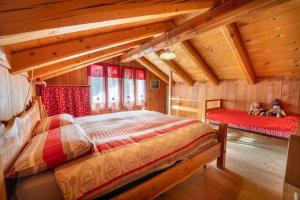 a bedroom with two beds in a log cabin at Baita Mas Sternai Nel Parco in Bagni di Rabbi