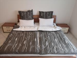 a bed with black and white sheets and pillows at Ferienwohnung Mössingen in Mössingen