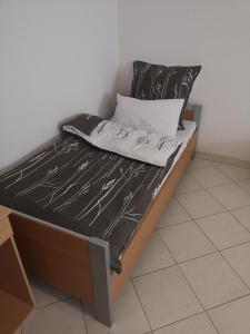 a bed with a black and white comforter on it at Ferienwohnung Mössingen in Mössingen +2 photos