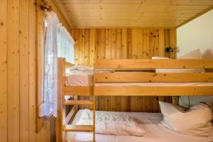 a bedroom with two bunk beds in a wooden cabin at Ferienhaus Lausekuppe Neustadt in Neustadt