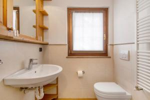 a bathroom with a sink and a toilet and a window at Residence Larice Bianco App n6 in Campodolcino +17 photos
