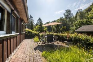 a patio with a table and an umbrella at Ferienhaus Lausekuppe Neustadt in Neustadt