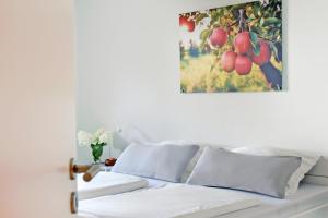 a bed with white sheets and a painting on the wall at Quartier Wellant in Weißensberg