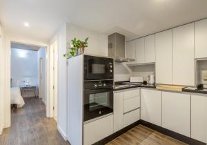a kitchen with white cabinets and an oven at Orbyz in Seville