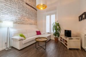a living room with a white couch and a table at Orbyz in Seville