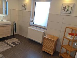 a small bathroom with a sink and a window at Ferienwohnung Dörnbergblick Klinge in Calden +7 photos