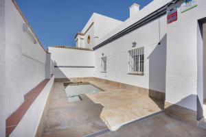 a hallway of a white building with a wooden floor at Casa Camposoto in San Fernando