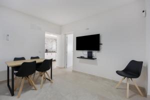 a dining room with a table and chairs and a tv at Casa Camposoto in San Fernando
