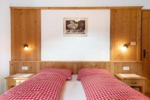 a bed with two red plaid pillows on it at Kaltenhauser Hof in Masserie